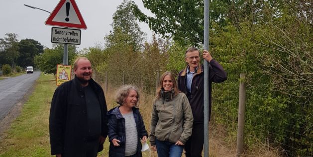 mitglieder-der-gruenen-neben-einer-haltestelle